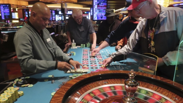A dealer conducts a game of roulette at a casino