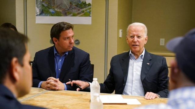 President Joe Biden, right, speaks as Florida Gov. Ron DeSantis, left, listens during a 2021 briefing.