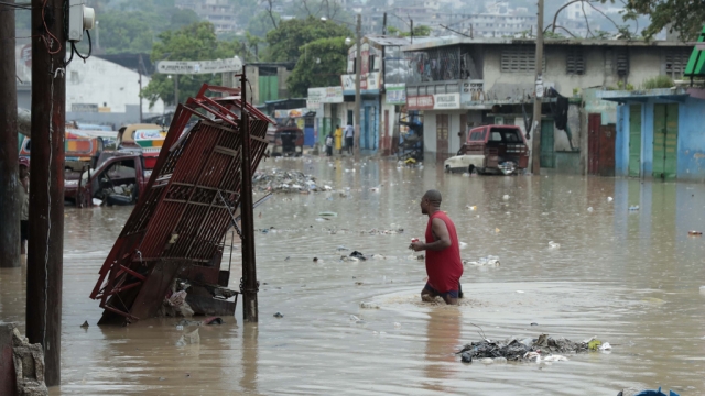 A man wades through a flooded street in Haiti.
