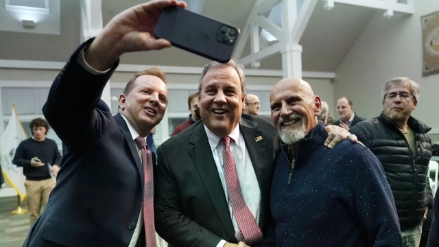 Former New Jersey Gov. Chris Christie, center, poses for a selfie.