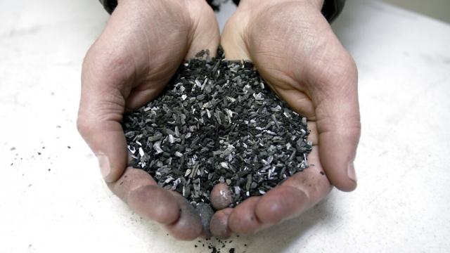 Person holding a sample of processed carbon, called biochar.