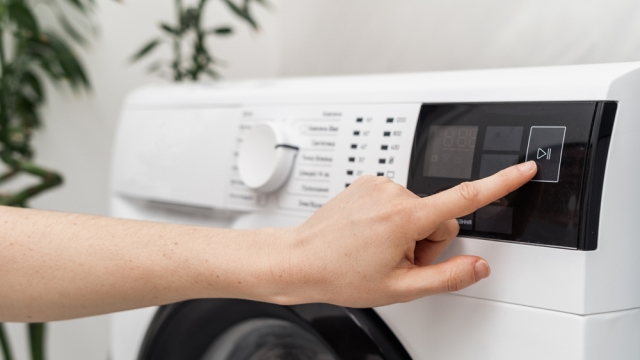 Person presses button on washing machine.