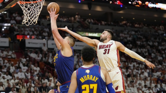 Denver Nuggets center Nikola Jokic (15) drives to the basket as Miami Heat guard Max Struss.