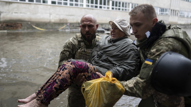 Ukrainian servicemen help an injured civilian who came under fire from Russian forces.