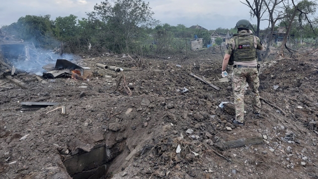 Ukrainian police officer inspects the scene of a Russian rocket attack.