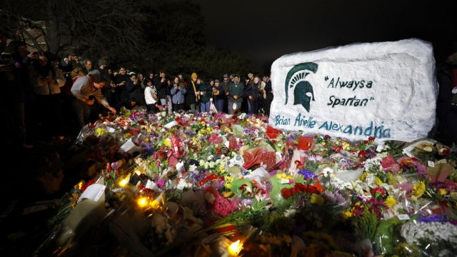 Mourners attend a vigil at The Rock on the grounds of Michigan State University.