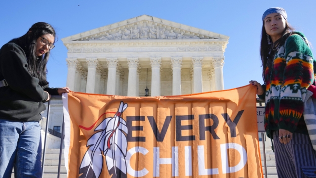 Demonstrators outside the U.S. Supreme Court hold a flag that says "Every Child Matters."