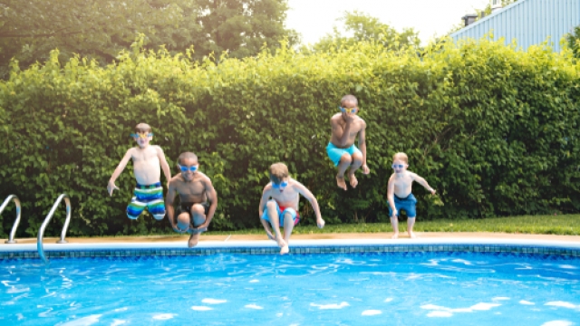 Children jumping into a pool.