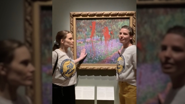 Two women stand in front of a Monet painting.