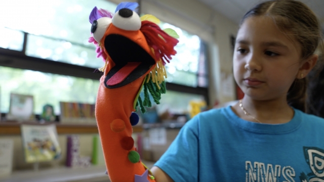 Child holding a sock puppet.
