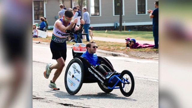 Sean McQuaid pushing Riley Pathman's wheelchair during marathon.