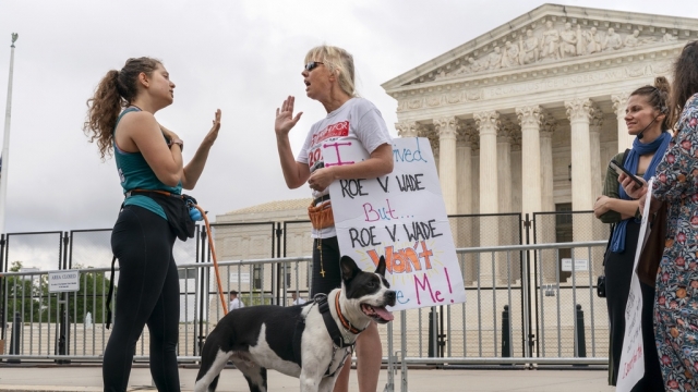 Lilo Blank, left, who supports abortion rights, and Lisa Verdonik, who is anti-abortion, discuss the issue at a protest.