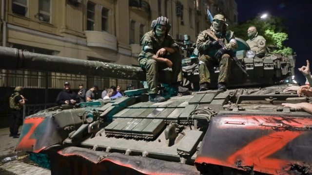 Membes of the Wagner Group military company sit atop of a tank on a street in Rostov-on-Don, Russia.