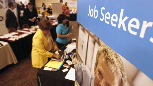 People walk by the recruiters at a jobs fair in the Pittsburgh suburb of Green Tree, Pa.