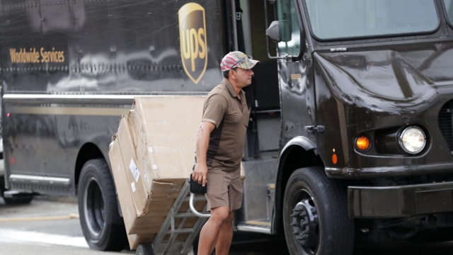 A UPS delivery worker unloads packages from his truck.
