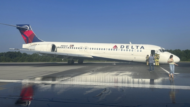 Airport and emergency personnel at the scene of a Delta plan that landed without its front landing gear.