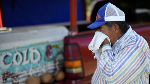 Andres Matamoros wipes the sweat from his face while selling fresh fruit in Texas.