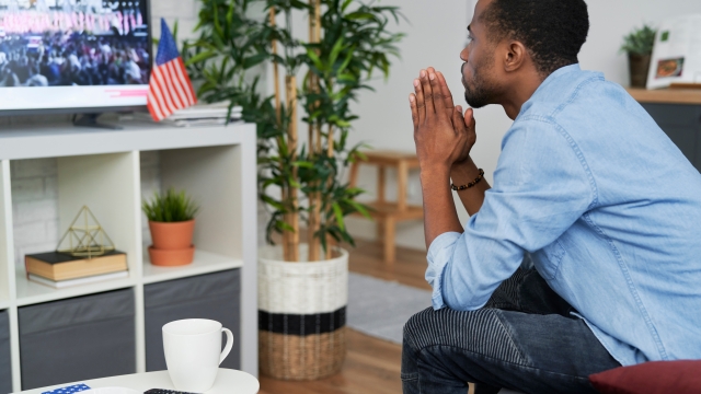 Man watches a TV with an American flag