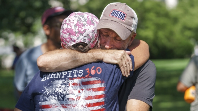 Veterans activist and entertainer Jon Stewart hugs a fellow advocate.