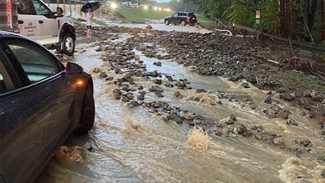 Vehicles come to a standstill near a washed-out and flooded portion of the Palisades Parkway