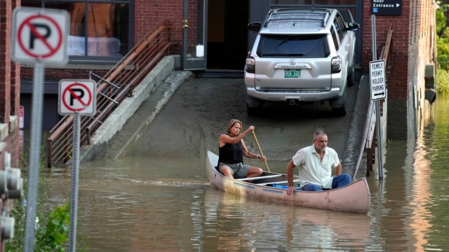 Veterinary staff use a canoe to remove surgical supplies from the flood-damaged center.