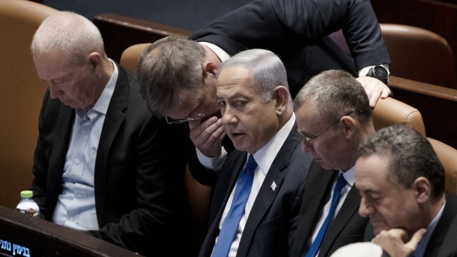 Lawmakers surround Israel's Prime Minister Benjamin Netanyahu.