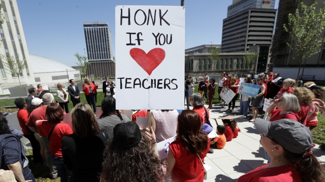 Protester holds honk if you love teachers sign