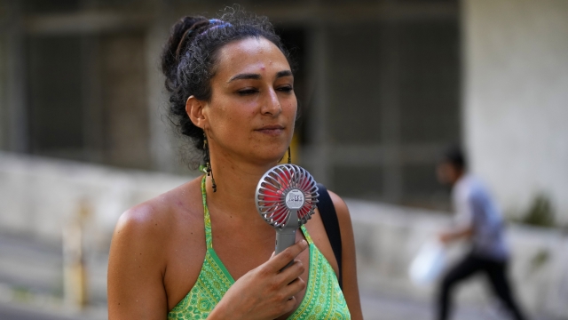 Woman cooling herself off with a fan