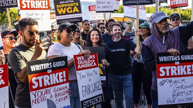 Writers on strike with signs in Hollywood