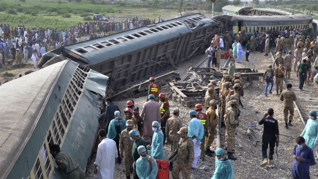 Rescue workers and army troops take in a rescue operation at the site of train derailed in Pakistan.