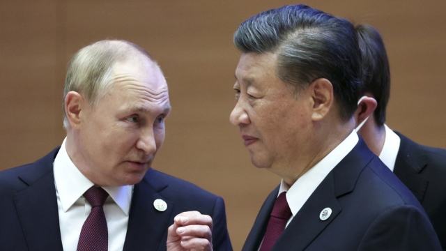 Russian President Vladimir Putin, left, gestures while speaking to Chinese President Xi Jinping.