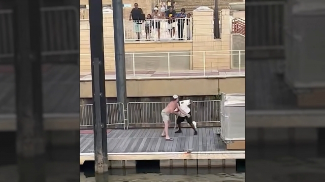 Two men fight on a dock.