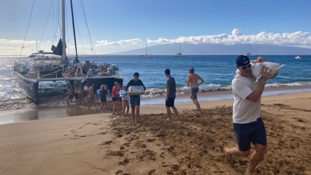 A group of volunteers who sailed from Maalaea Bay, Maui, form an assembly line on Kaanapali Beach.