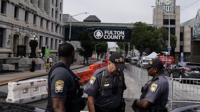 Authorities stand near barricades at the Fulton County courthouse in Georgia before a potential indictment of Donald Trump.