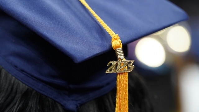 A tassel with 2023 on it rests on a graduation cap.