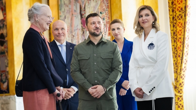 Queen Margrethe II of Denmark, left, speaks with Ukrainian President Volodymyr Zelenskyy, center, and his wife.