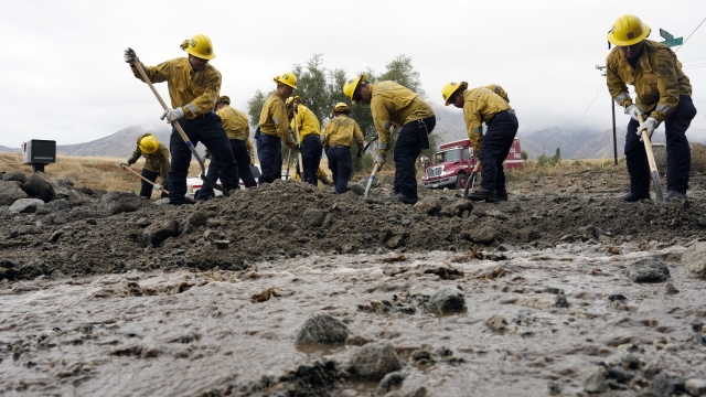 Firefighters clearing mud off the road