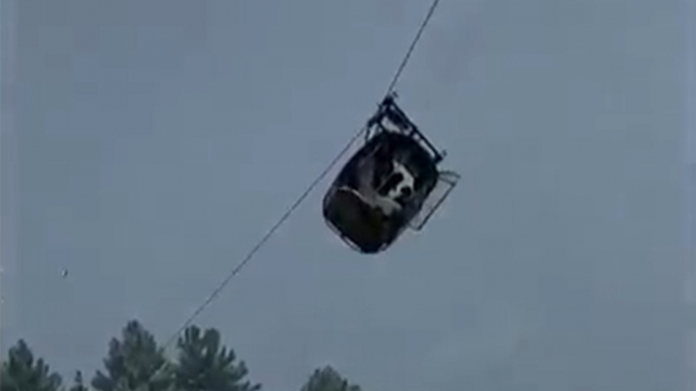 A cable car carrying six children and two adults dangles hundreds of feet above the ground in Pakistan after a cable broke.