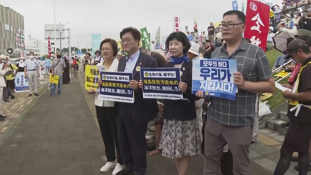 South Korean lawmakers from left, Kang Eun-mi, Woo Wonshik and Yang Jung-suk, hold placards  during protest.