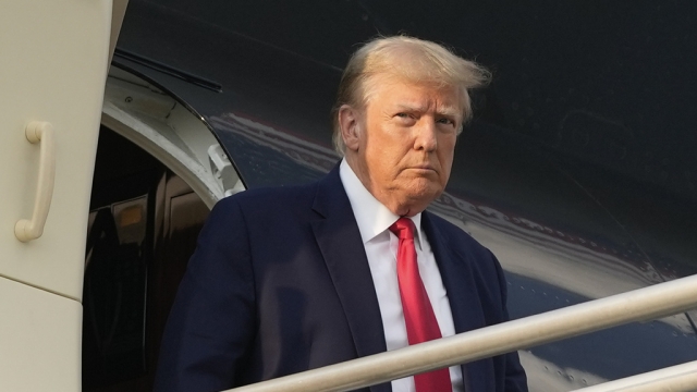 Former President Donald Trump steps off his plane as he arrives in Atlanta.