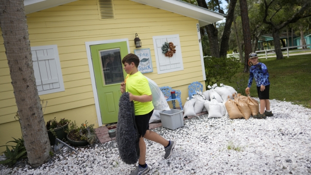 Two boys in Gainesville help move personal belongings out of their home as Hurricane Idalia nears.