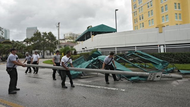 Members of the Tampa Fire Rescue Dept., remove a street pole.