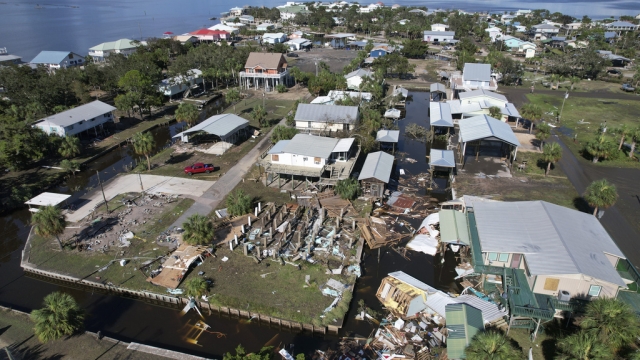 Debris from homes swept off their lots litters a canal in Horseshoe Beach, Fla.