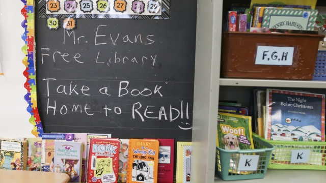 Books are displayed on a free library shelf inside the classroom