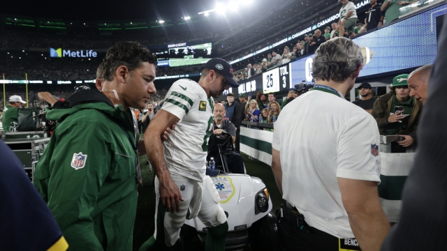 New York Jets quarterback Aaron Rodgers is helped off the field after an injury.