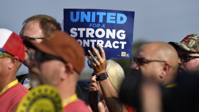 A member holds up a sign at a rally by United Auto Workers Local 863 in Louisville, Ky.
