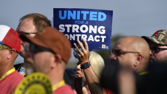 A member holds up a sign at a rally by United Auto Workers Local