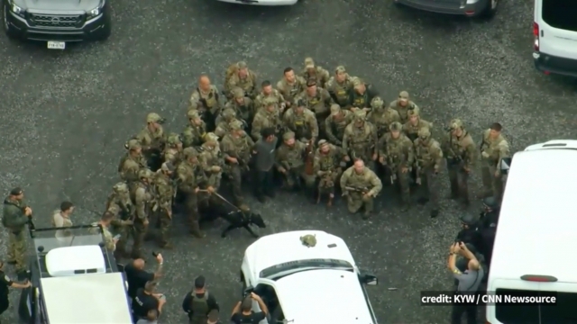 Heavily armed police gather around Danelo Cavalcante for a group photo after his capture.