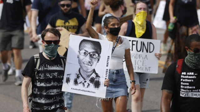 Demonstrators carry placards during a rally and march over the death of Elijah McClain