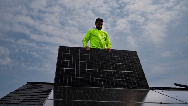 A worker installs solar panels in Kentucky